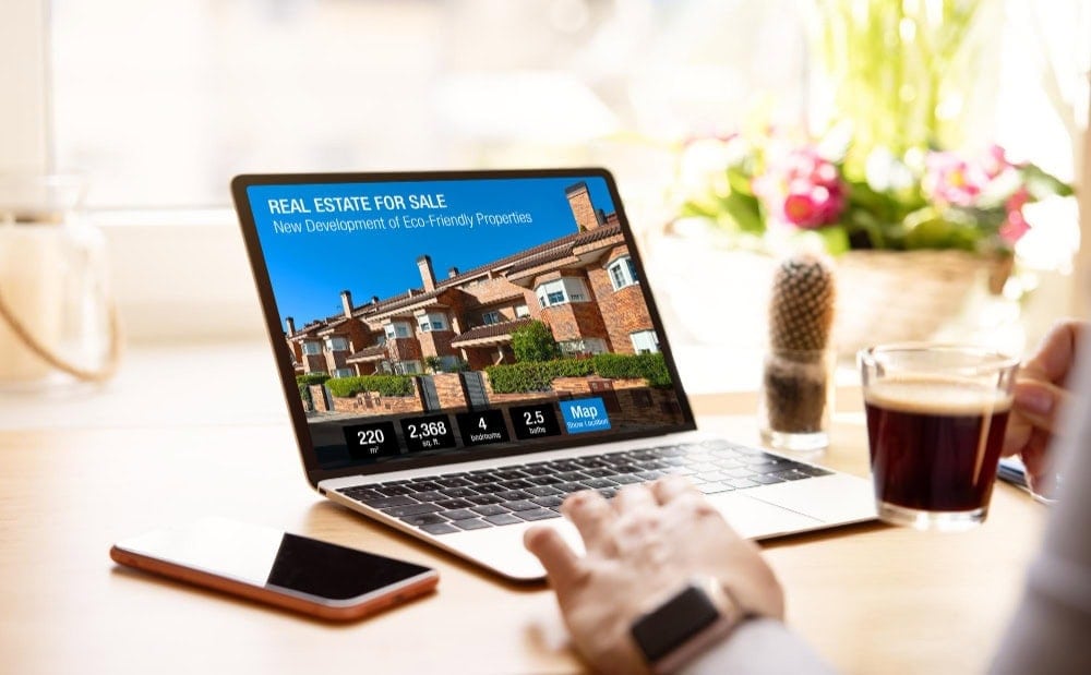 Real estate laptop displaying property listings for sale and development.